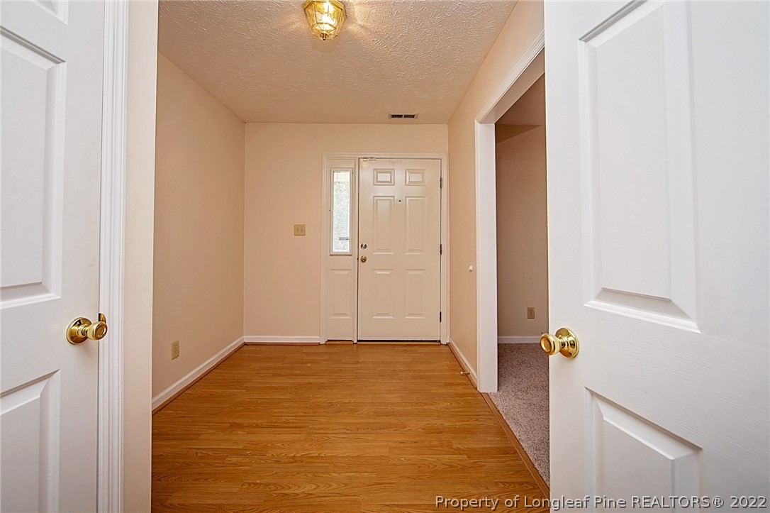 138 Pecan Trace Road Raeford, NC 28376 - Photo 29 of 42 a view of a hallway with wooden floor and a bathroom