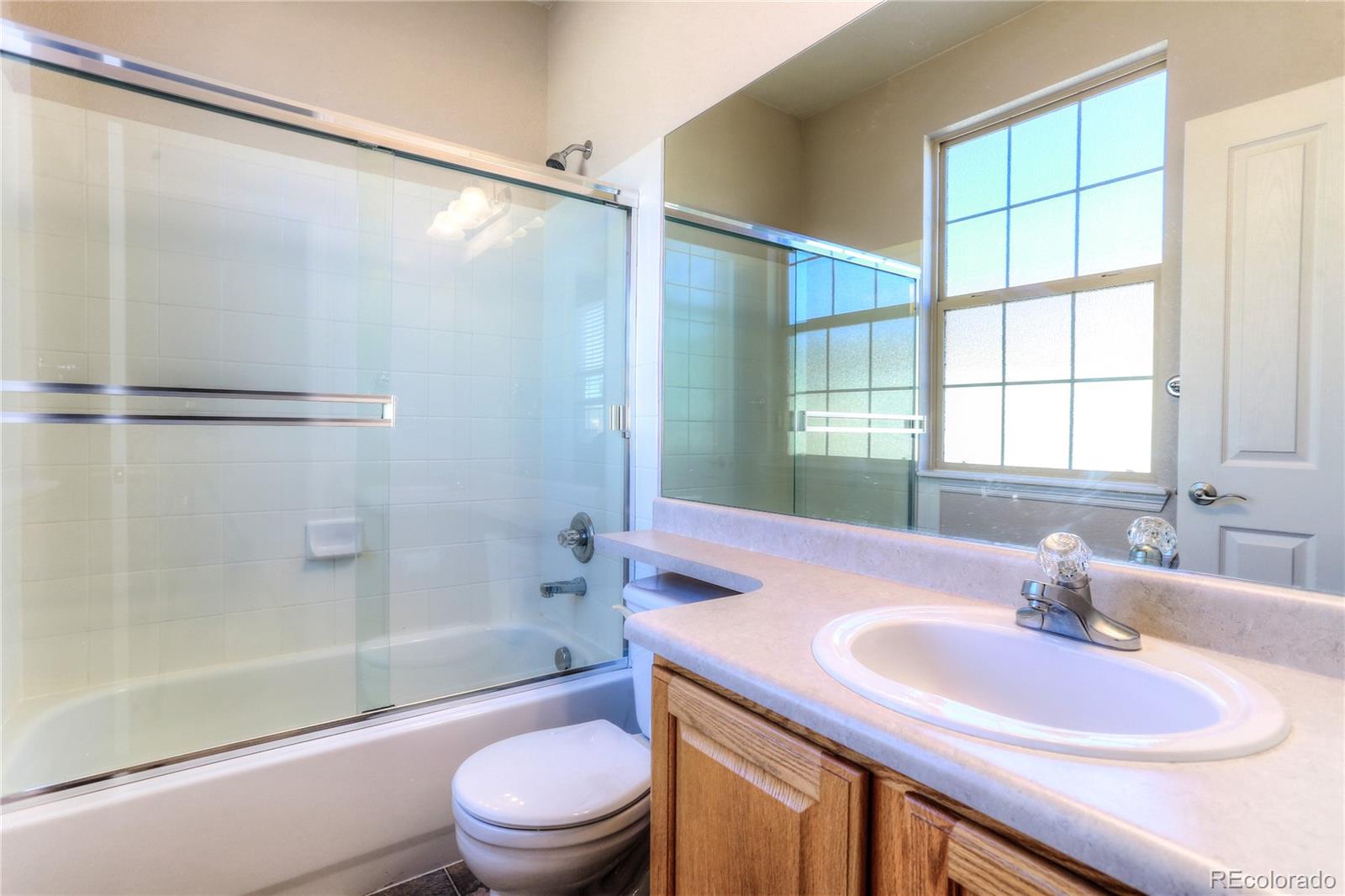 10178 RidgeGate Circle Lone Tree, CO 80124 - Photo 18 of 22 a bathroom with a granite countertop sink toilet and shower