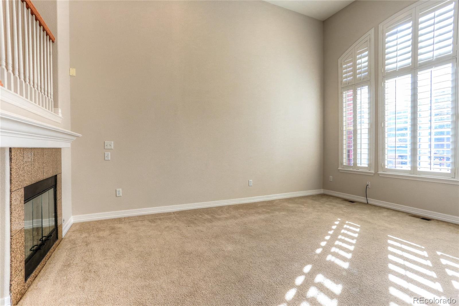 10178 RidgeGate Circle Lone Tree, CO 80124 - Photo 5 of 22 a view of an empty room with a fireplace and a window