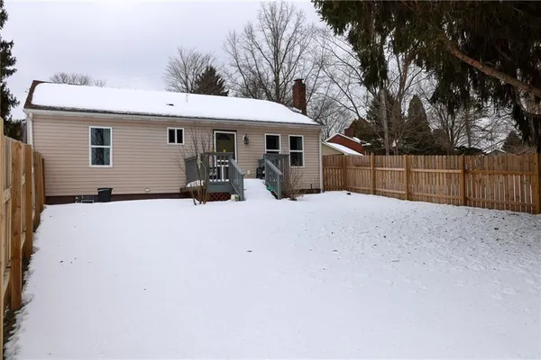 a view of a house with a yard covered in snow