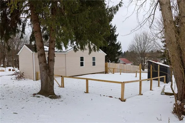 a view of a white house with a snow in the yard