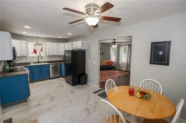 a kitchen with stainless steel appliances granite countertop a sink dishwasher a refrigerator with wooden cabinets and floor