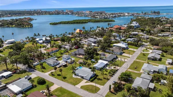 an aerial view of city and lake with trees all around