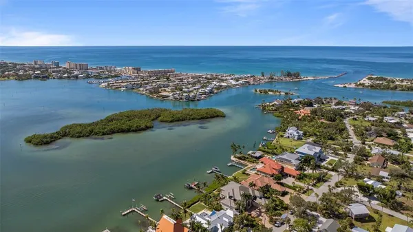 an aerial view of ocean and residential houses with outdoor space
