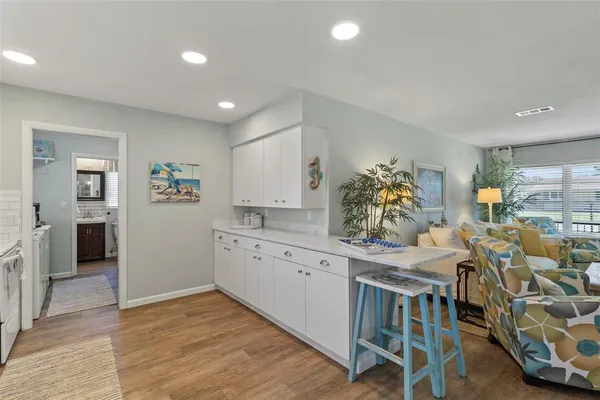 a kitchen with granite countertop a table chairs stove and cabinets