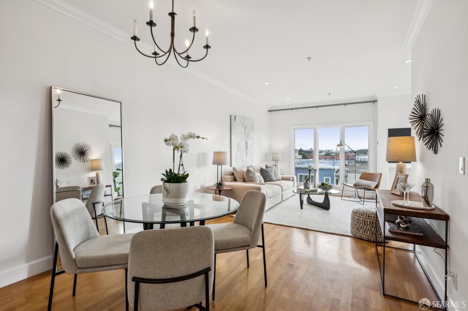 a dining room with furniture a chandelier and wooden floor