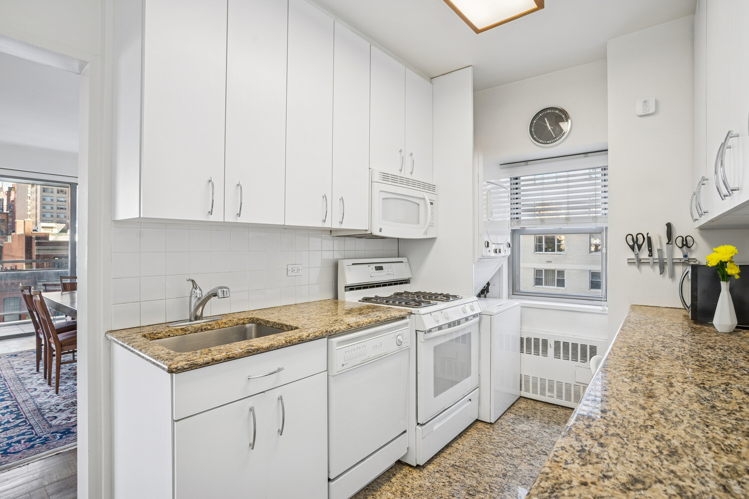 150 East 69th Street, Unit 5J Manhattan, NY 10021 - Photo 6 of 11 a kitchen with a sink stove and cabinets
