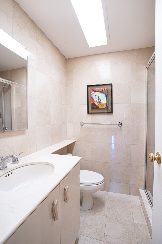 150 East 69th Street, Unit 5J Manhattan, NY 10021 - Photo 9 of 11 a bathroom with a sink a toilet and a mirror