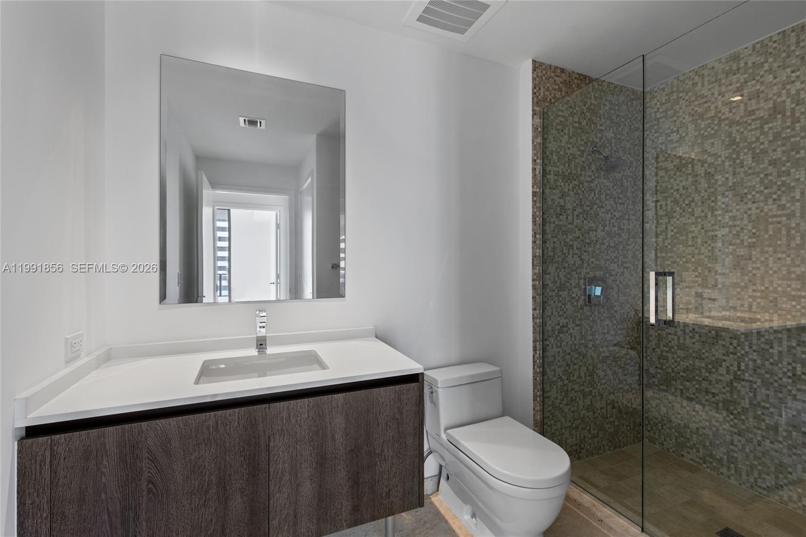 88 Southwest 7th Street, Unit 904 Miami, FL 33130 - Photo 18 of 26 a bathroom with a sink vanity mirror and toilet