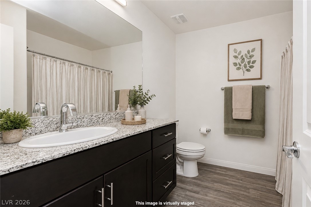 12369 Golden Wreath Road, Unit 2 Las Vegas, NV 89183 - Photo 13 of 19 A refined bathroom featuring a spacious vanity with granite counters, modern cabinetry, and sleek fixtures.