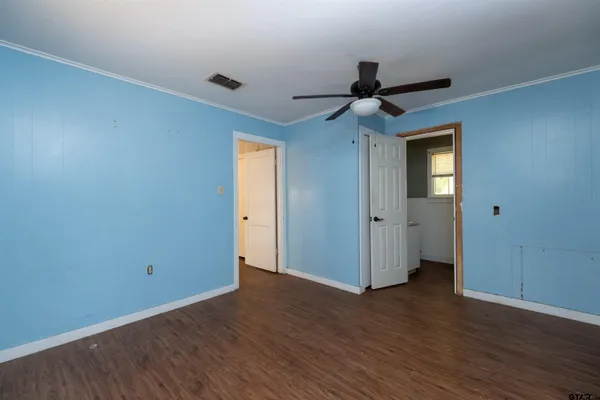 a view of a hallway with wooden floor and a chandelier fan