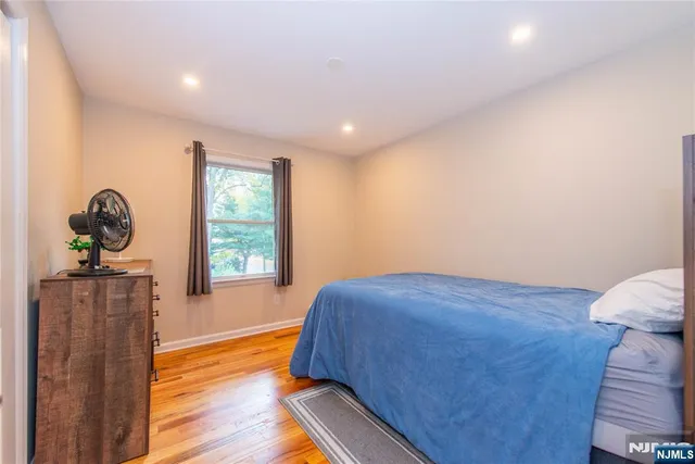 a bedroom with a bed and wooden floor
