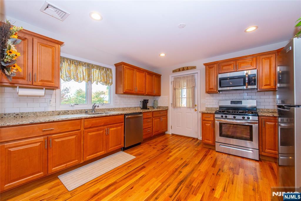 5 Mountain Avenue, Unit 2 Wanaque, NJ 07465 - Photo 2 of 20 a large kitchen with stainless steel appliances granite countertop a stove and a sink