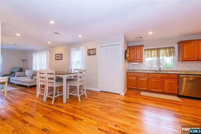 a living room with dining room wooden floor and kitchen view