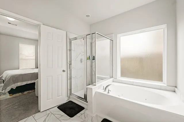 a bathroom with a tub shower and window