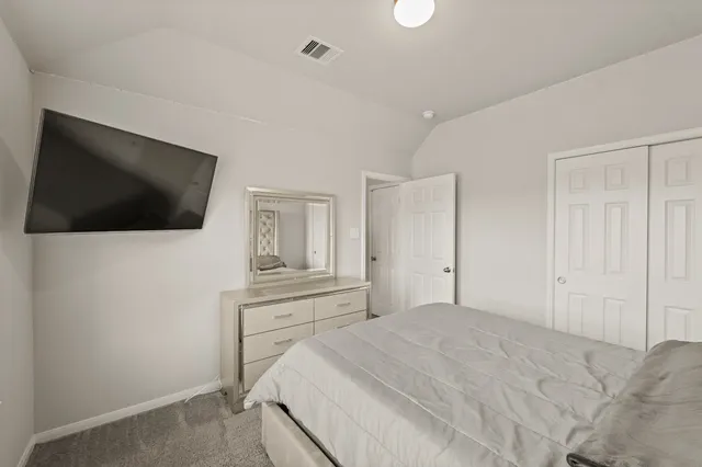 a bedroom with a bed and a flat screen tv