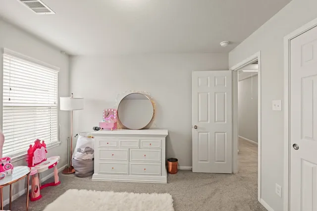 a room with a baby crib cabinets and a window