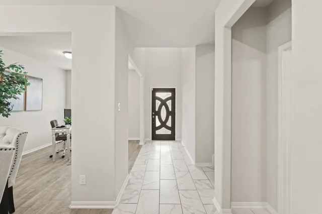 a view of a hallway with wooden floor and windows