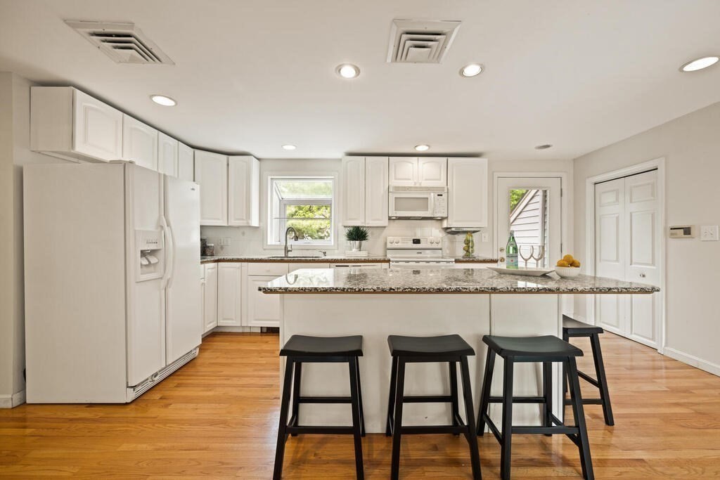 67 Sherburne Road South Lexington, MA 02421 - Photo 12 of 29 a kitchen with granite countertop white cabinets refrigerator and chairs
