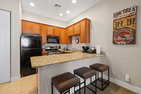 a kitchen with stainless steel appliances granite countertop a sink refrigerator and microwave