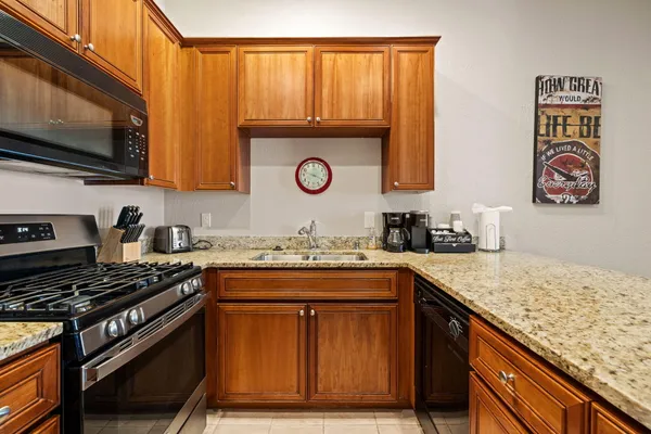 a kitchen with stainless steel appliances granite countertop a stove and a sink