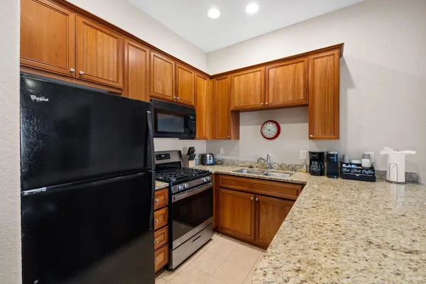 a kitchen with stainless steel appliances granite countertop a stove a refrigerator and a sink