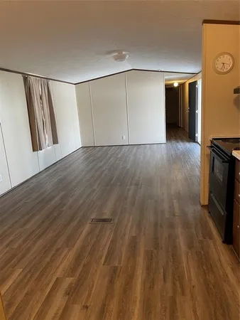 an empty room with wooden floor and staircase
