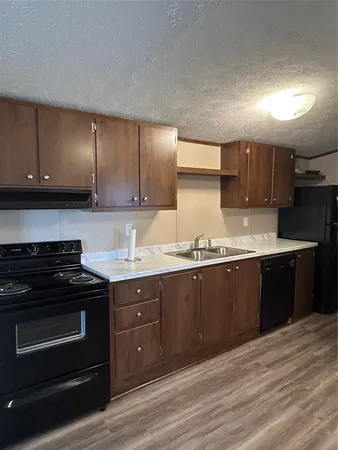 a kitchen with granite countertop wooden cabinets and stainless steel appliances