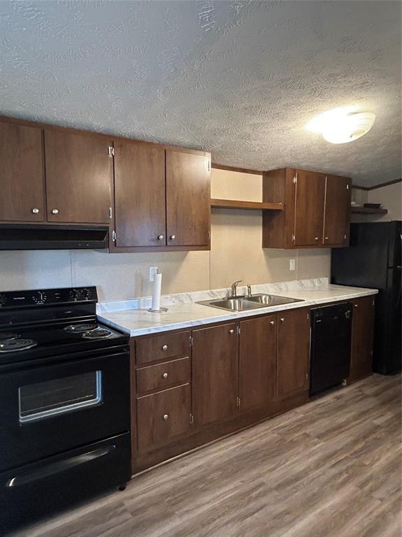 128 Blackjack Road Valley View, TX 76272 - Photo 4 of 13 a kitchen with granite countertop wooden cabinets and stainless steel appliances