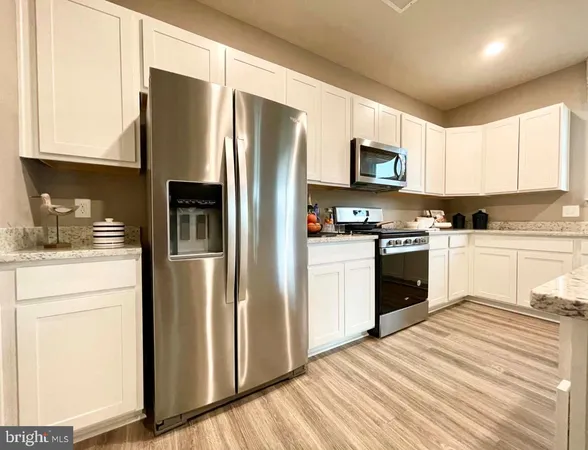 a kitchen with stainless steel appliances granite countertop a refrigerator stove and sink
