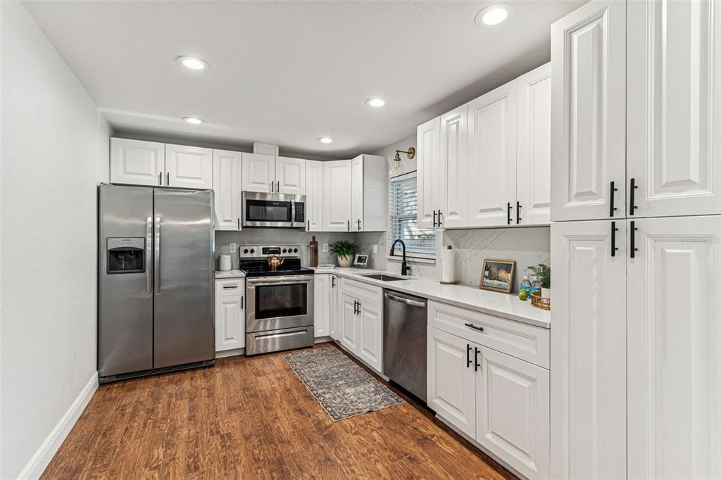 727 Locust Street Tarpon Springs, FL 34689 - Photo 12 of 47 a kitchen with white cabinets stainless steel appliances and a window