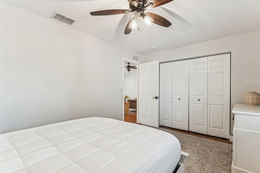 727 Locust Street Tarpon Springs, FL 34689 - Photo 22 of 47 a bedroom with a large bed and a chandelier fan