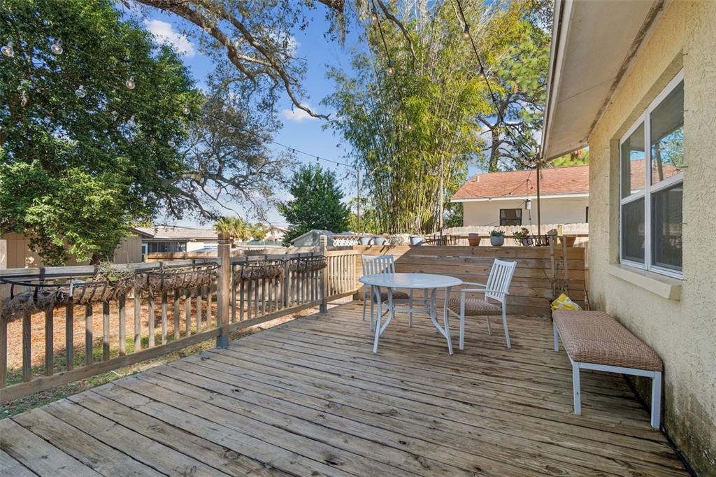727 Locust Street Tarpon Springs, FL 34689 - Photo 27 of 47 a view of a roof deck with table and chairs wooden floor and fence