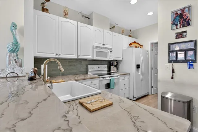 a kitchen with stainless steel appliances granite countertop a sink refrigerator and cabinets