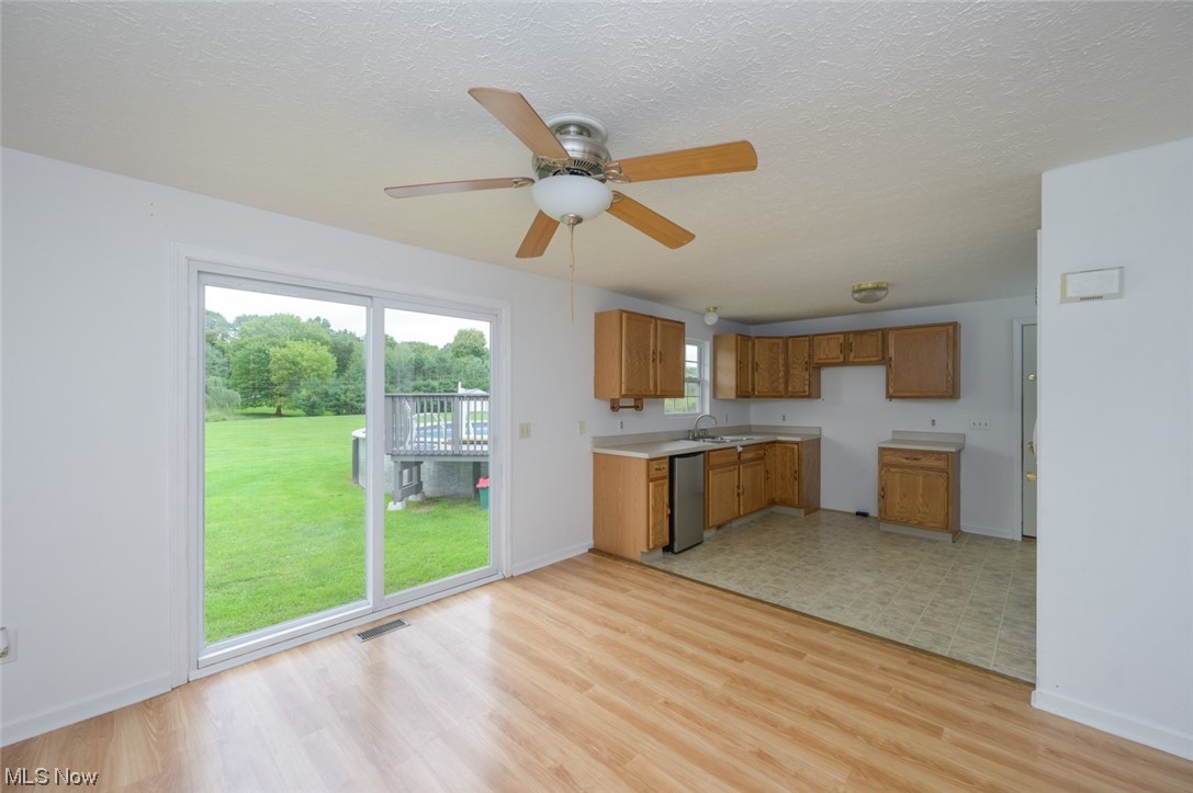 8045 State Rte 5 Ravenna, OH 44266 - Photo 20 of 32 Kitchen with ceiling fan, stainless steel dishwasher, brown cabinets, and light tile floors
