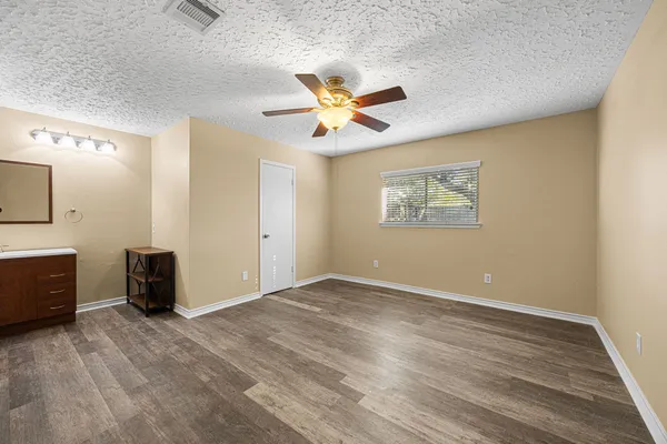 an empty room with closet and a ceiling fan