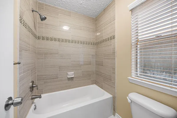 a bathroom with a shower a toilet and a bath tub