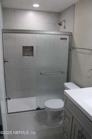 a white toilet sitting next to a bath tub