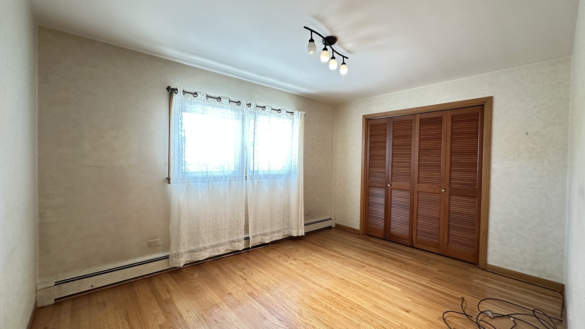 5219 North Bernard Street, Unit 1 Chicago, IL 60625 - Photo 12 of 13 wooden floor and windows in an empty room