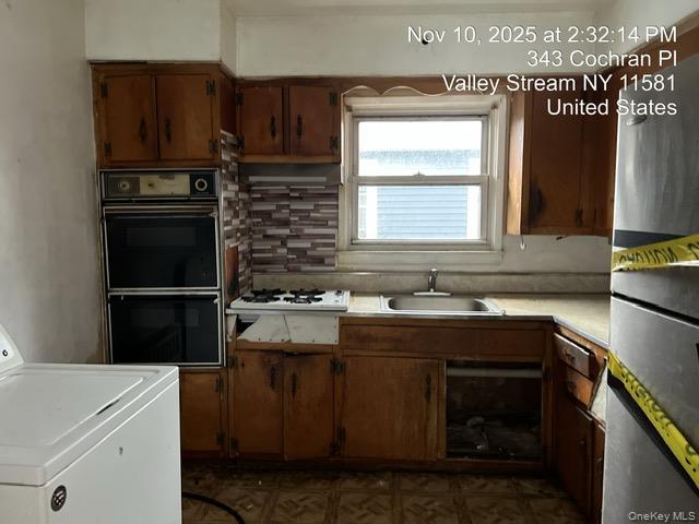 343 Cochran Place Valley Stream, NY 11581 - Photo 11 of 17 a kitchen with a sink stove and refrigerator