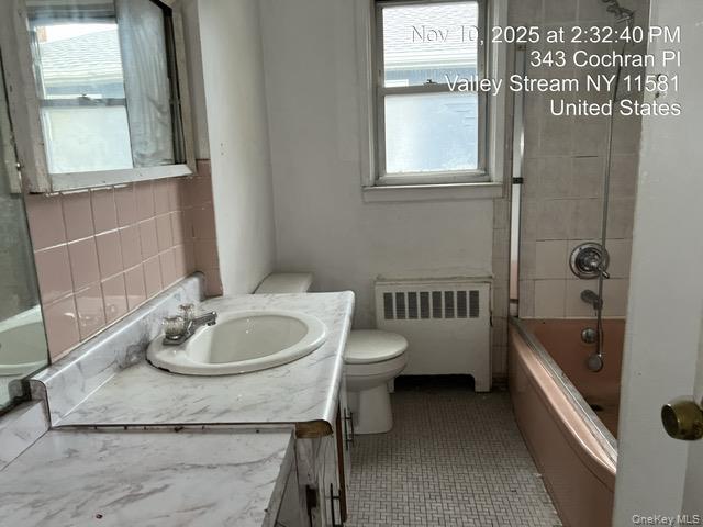 343 Cochran Place Valley Stream, NY 11581 - Photo 12 of 17 a bathroom with a granite countertop sink a toilet and bathtub