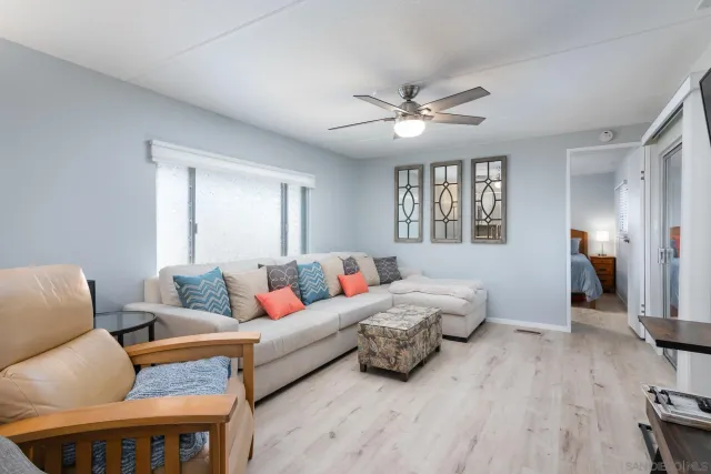 a living room with furniture two window and a wooden floor