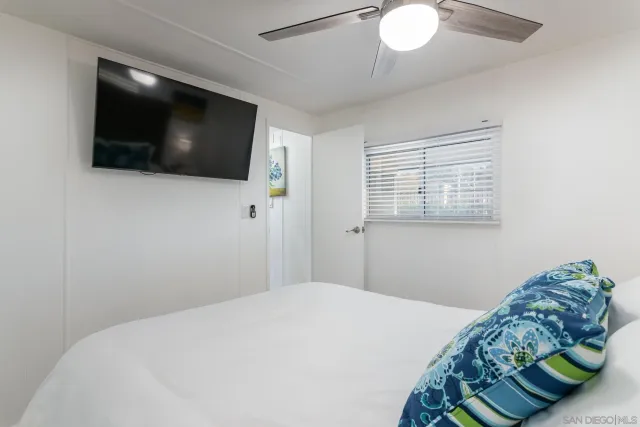 a bedroom with a bed and a flat screen tv