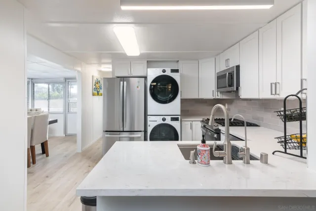 a kitchen with white cabinets and sink