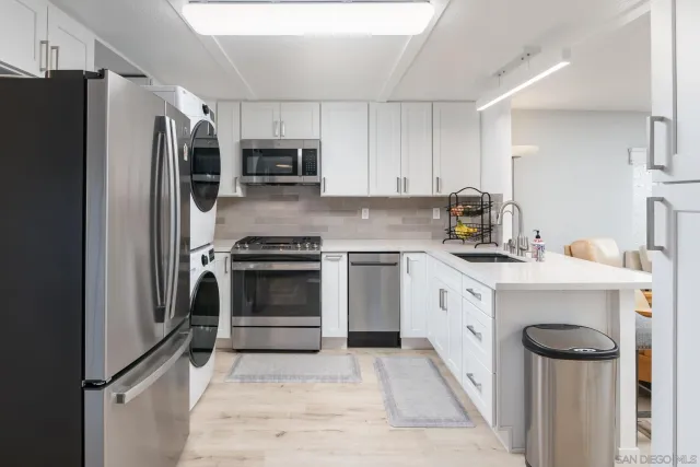 a kitchen with stainless steel appliances a stove a sink and a refrigerator