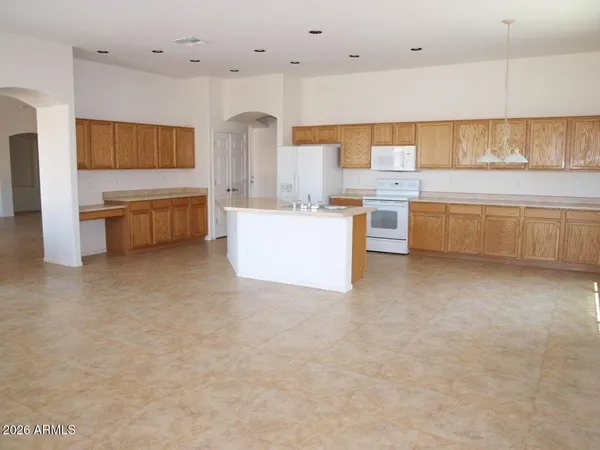 a large white kitchen with a large window and stainless steel appliances