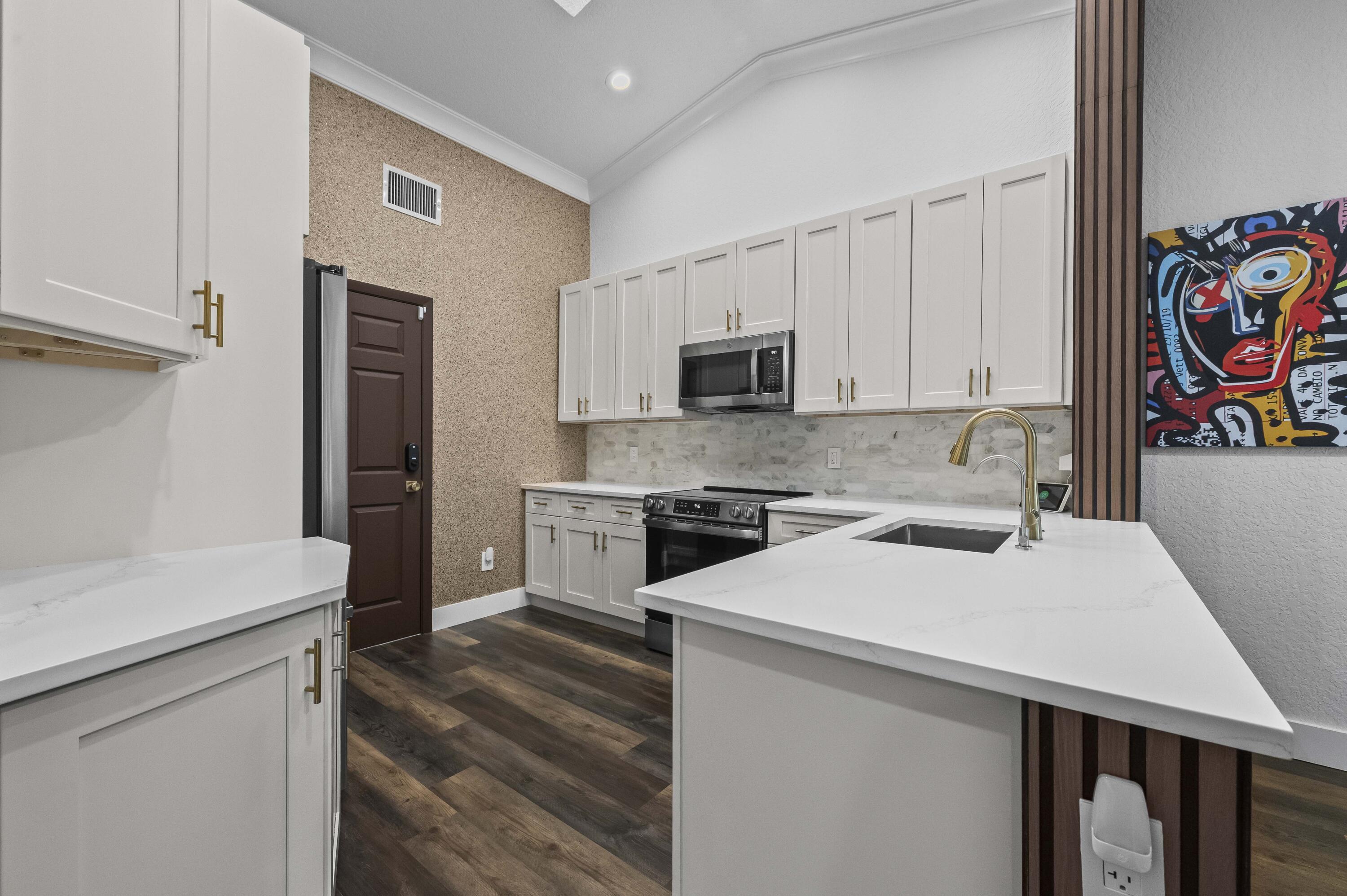 17257 Boca Club Boulevard, Unit 4 Boca Raton, FL 33487 - Photo 11 of 35 a kitchen with a sink a stove a microwave and a refrigerator