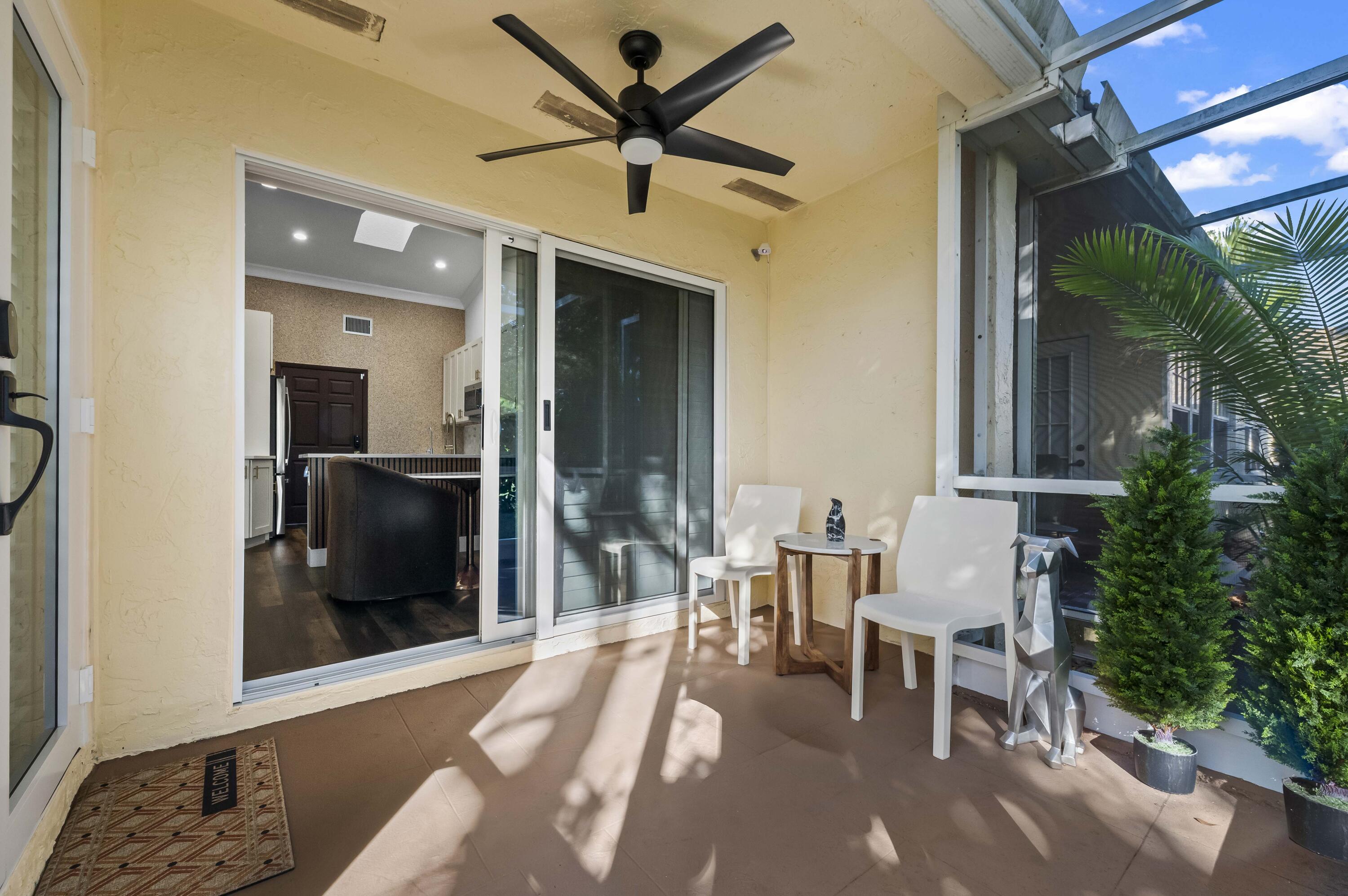 17257 Boca Club Boulevard, Unit 4 Boca Raton, FL 33487 - Photo 30 of 35 a living room with furniture and a flat screen tv