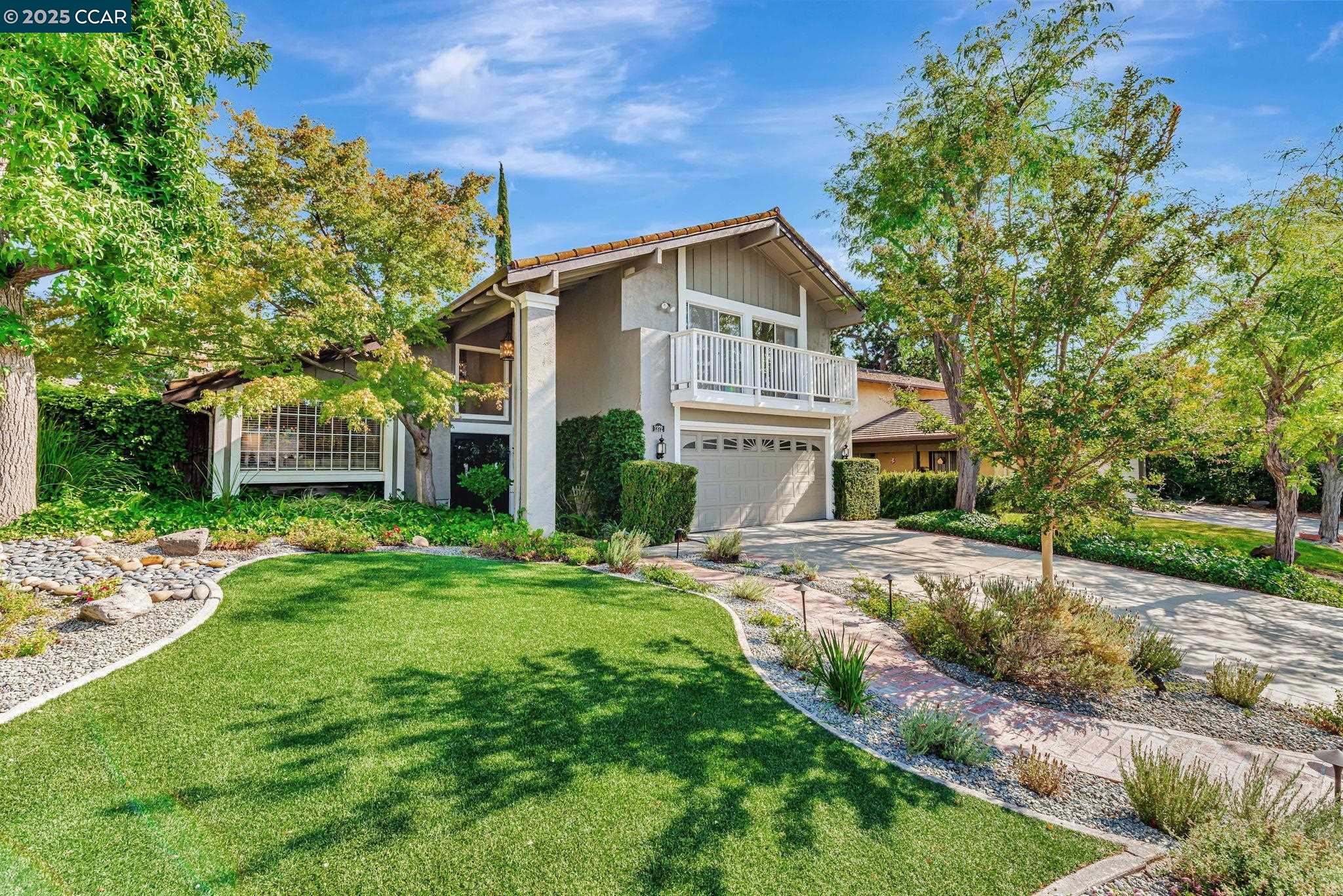 a view of a house with a yard and potted plants