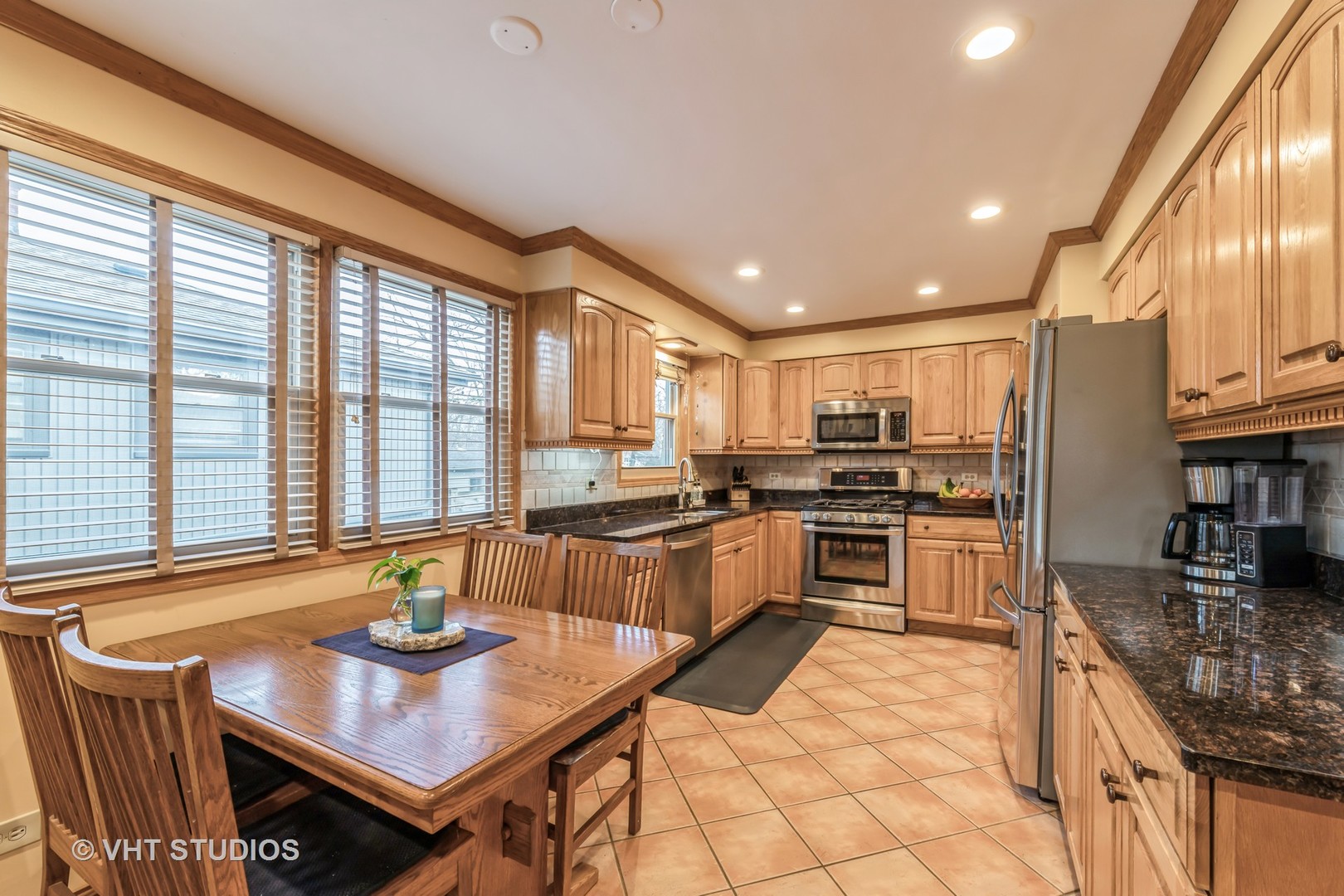1423 Burr Oak Road Homewood, IL 60430 - Photo 4 of 12 a large kitchen with kitchen island granite countertop a stove a sink a dining table and chairs